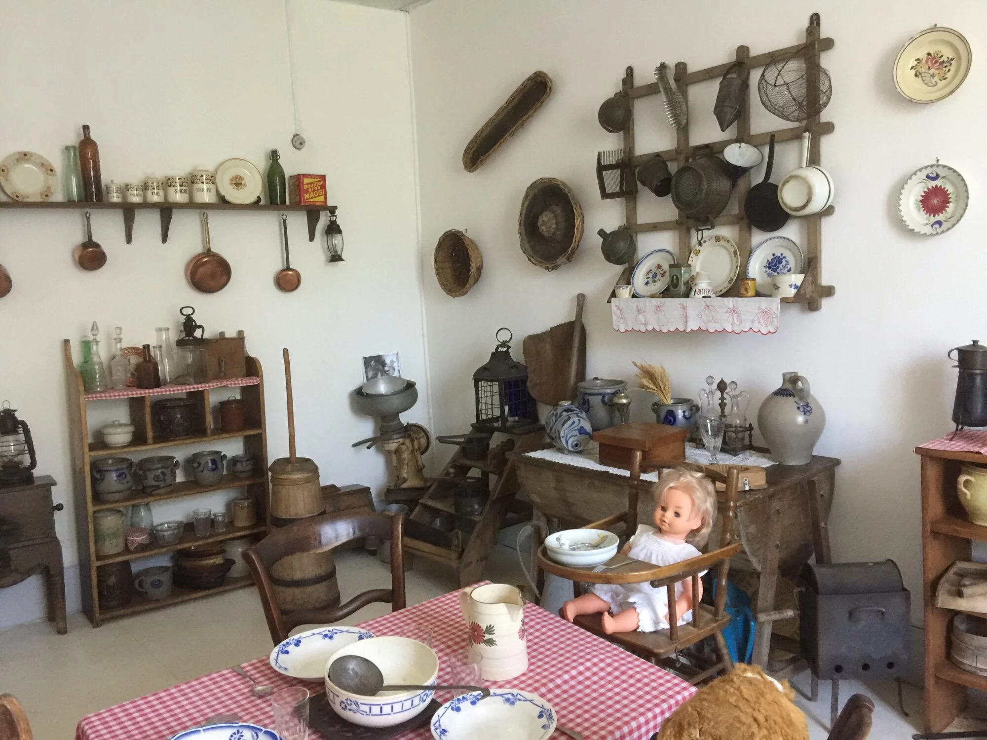 Inside the Maison du Patrimoine: an old-fashioned kitchen with crockery, utensils and antique furniture