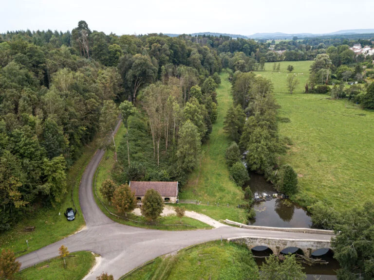 Aerial view of a stone bridge over the Saône, a road and the forest near Monthureux-sur-Saône