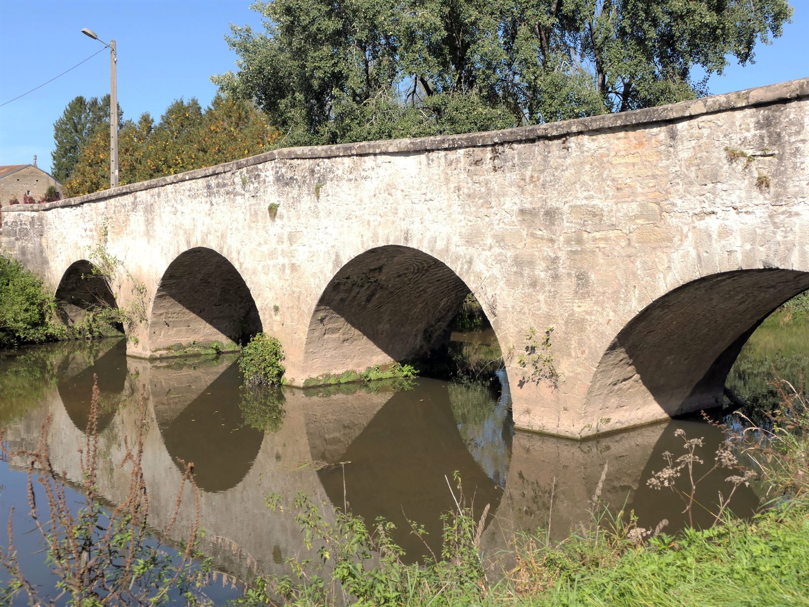 The Pont des Prussiens, a stone arched bridge reflected in the water