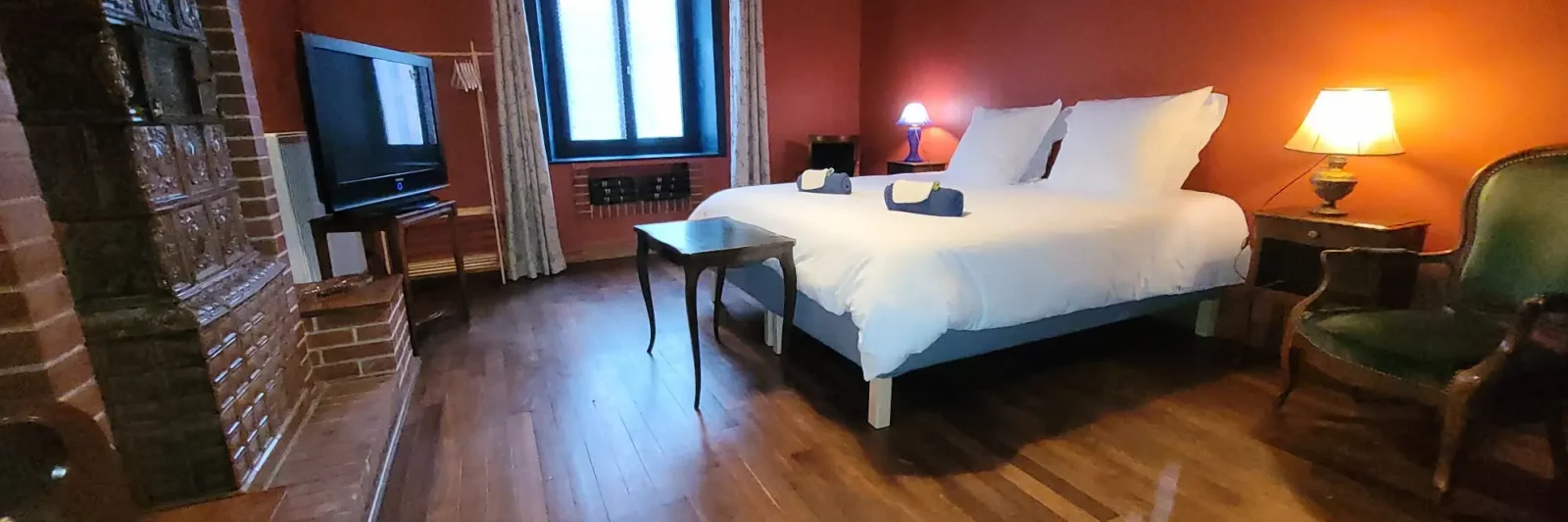 Chambre de plein pied Maison Cœurdacier Monthureux‑sur‑Saône Vosges — grand lit, fauteuils et décoration chaleureuse.