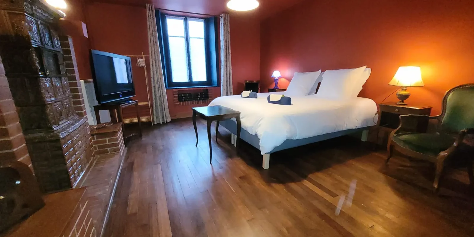 Chambre de plein pied Maison Cœurdacier Monthureux‑sur‑Saône Vosges — grand lit, fauteuils et décoration chaleureuse.