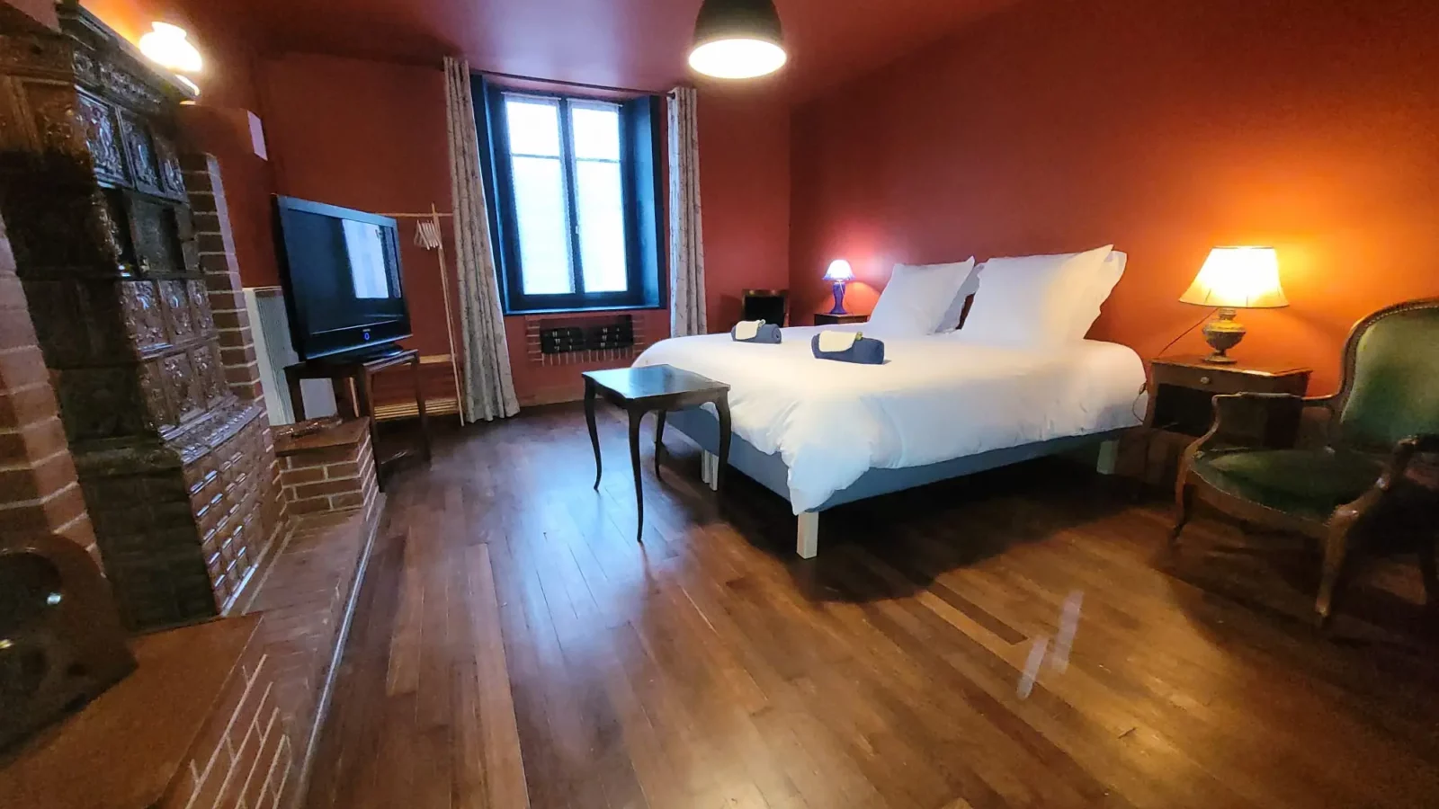 Chambre de plein pied Maison Cœurdacier Monthureux‑sur‑Saône Vosges — grand lit, fauteuils et décoration chaleureuse.