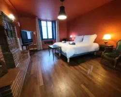 Chambre de plein pied Maison Cœurdacier Monthureux‑sur‑Saône Vosges — grand lit, fauteuils et décoration chaleureuse.