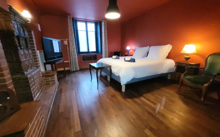 Chambre de plein pied Maison Cœurdacier Monthureux‑sur‑Saône Vosges — grand lit, fauteuils et décoration chaleureuse.