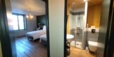 Chambre et salle de douche privative vues à travers deux portes ouvertes